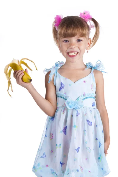 Mooi meisje in een blauwe jurk met een banaan in haar handen — Stockfoto