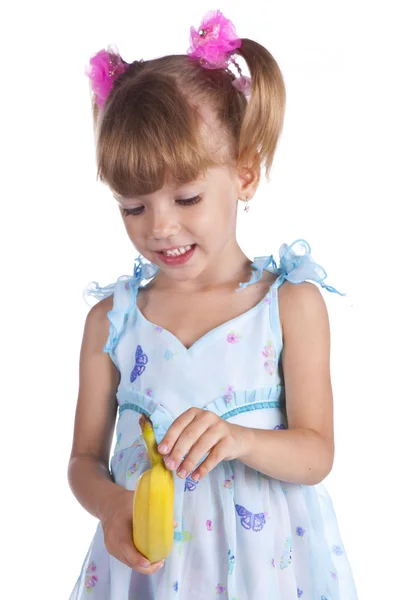 Menina bonita em um vestido azul com uma banana em suas mãos — Fotografia de Stock