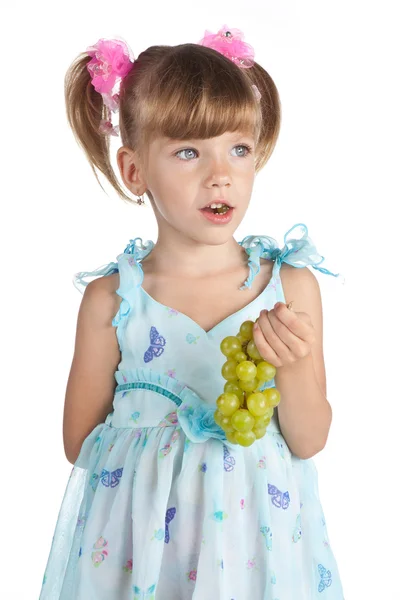 Красивая маленькая девочка с зеленым виноградом в руке — стоковое фото