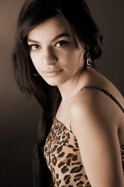 En mycket vacker brunett tjej i leopard tunika poserar i studio — Stockfoto