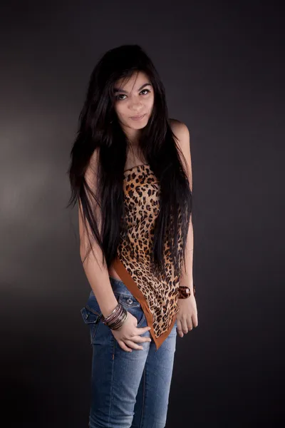 Дуже красива дівчина брюнетка в леопард туніки позує в студії — стокове фото