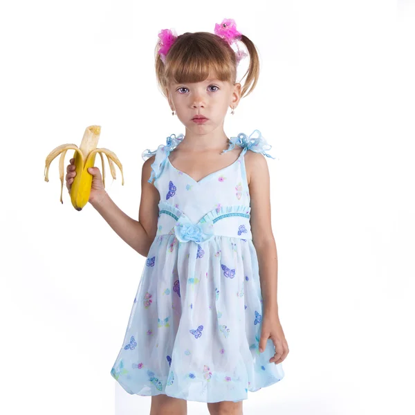 Όμορφο κορίτσι σε ένα μπλε φόρεμα με μια μπανάνα στα χέρια της — Φωτογραφία Αρχείου