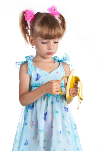 Pretty girl in a blue dress with a banana in her hands — Stock Photo, Image