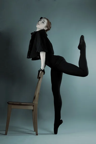 Joven bailarina realiza ejercicios cerca de la silla — Foto de Stock