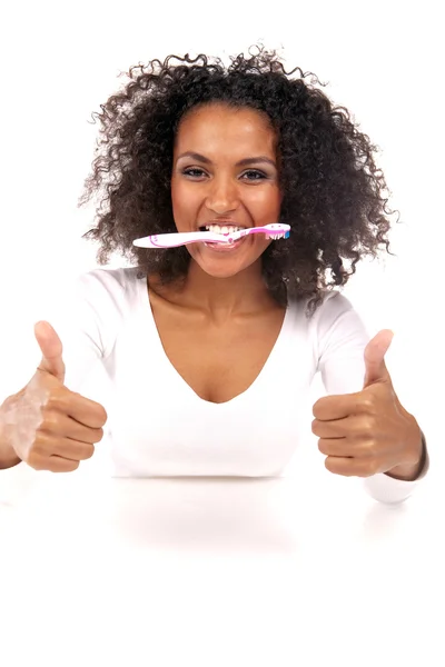 Portrait of a beautiful black woman cleaning her teeth — Stock Photo, Image