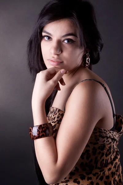 A very beautiful brunette girl in leopard tunic posing in studio — Stock Photo, Image