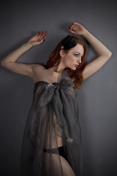 Руда дівчина в сукні чорної прозорої тканини — стокове фото