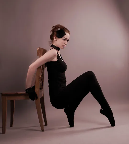 Молода балерина виконує вправи біля крісла — стокове фото
