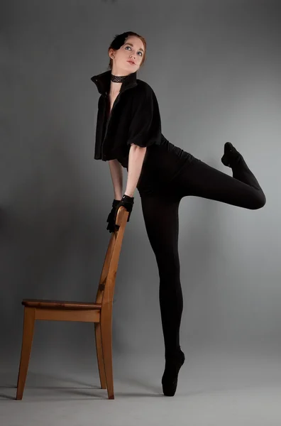 Joven bailarina realiza ejercicios cerca de la silla — Foto de Stock