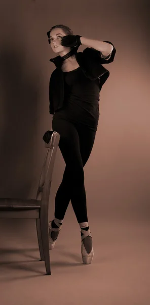 Mladá baletka provádí cvičení v blízkosti židličky — Stock fotografie