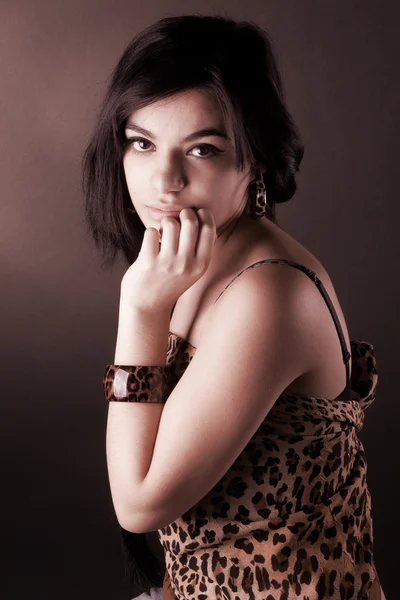Дуже красива дівчина брюнетка в леопард туніки позує в студії — стокове фото