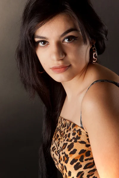 Ein sehr schönes brünettes Mädchen in Leopardenmantel posiert im Studio — Stockfoto