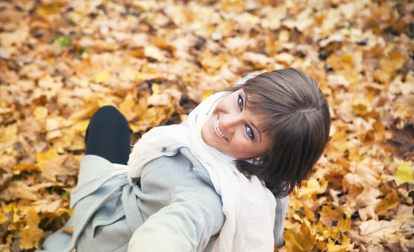Flicka på en bakgrund av hösten lämnar — Stockfoto