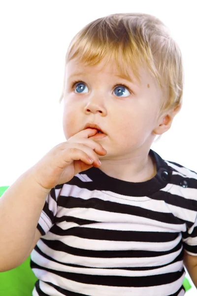 Un niño pequeño con la camisa a rayas se sienta —  Fotos de Stock
