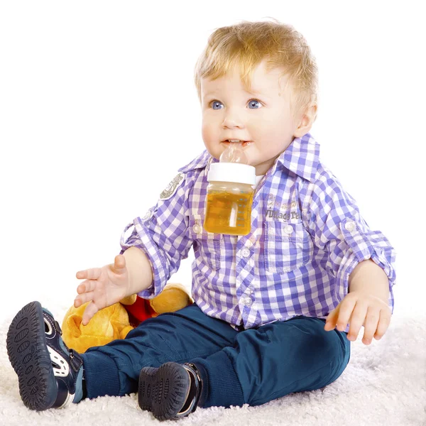 Un niño pequeño con la camisa a rayas se sienta — Foto de Stock