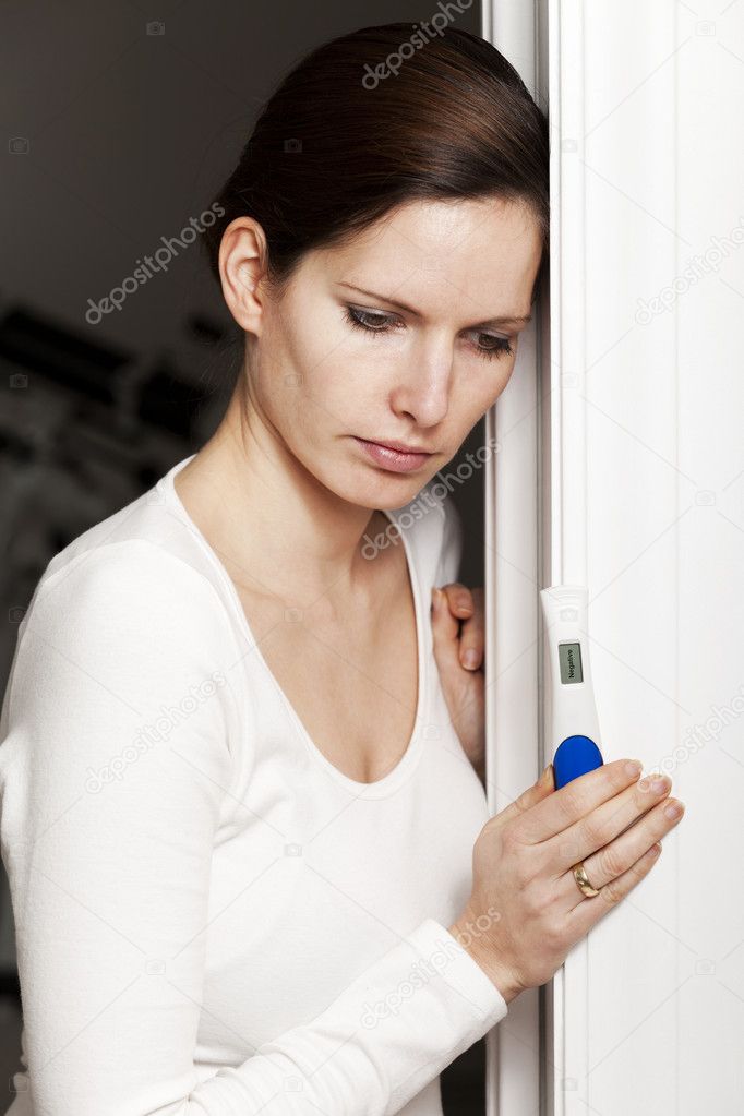 Sad woman with negative pregnancy test