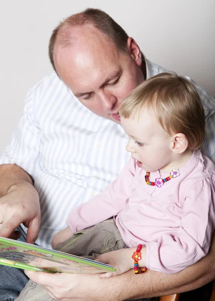 Father and baby daughter reading — Stock Photo, Image
