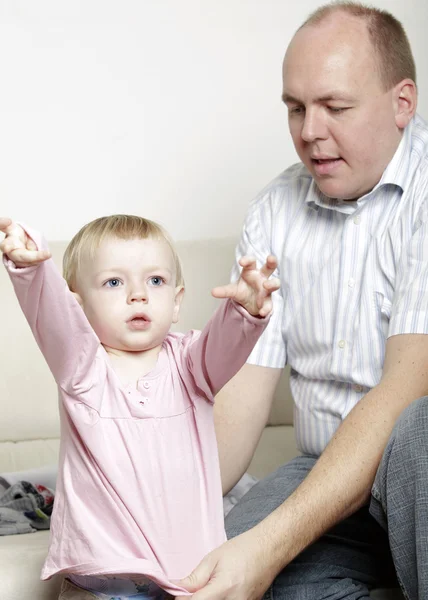 Father helping his baby daughter dress — Stock Photo, Image