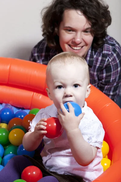 Ребенок играет с разноцветными шариками — стоковое фото