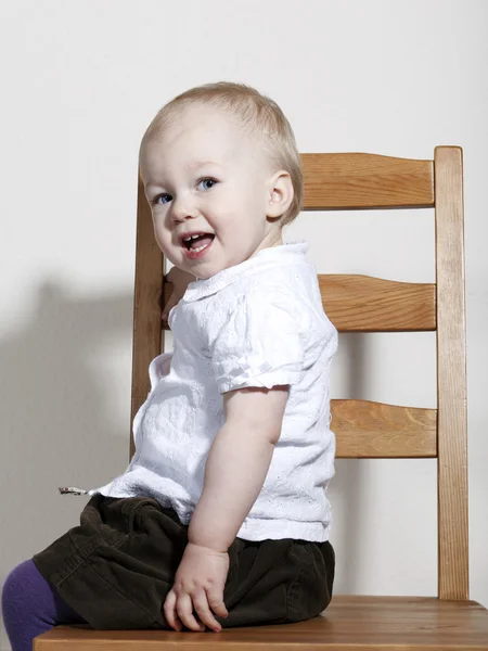 Stolzes, glückliches Baby auf Stuhl sitzend — Stockfoto