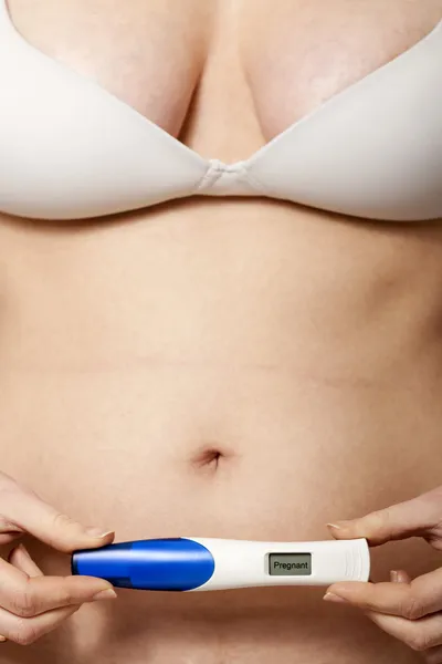 Mulher grávida mostrando teste de gravidez positivo — Fotografia de Stock