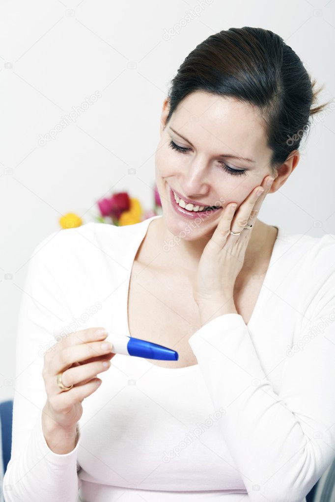 Happy woman with positive pregnancy test