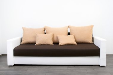 Modern couch at white wall clipart