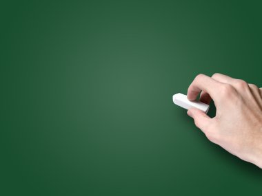 Hand with chalk on blank blackboard clipart