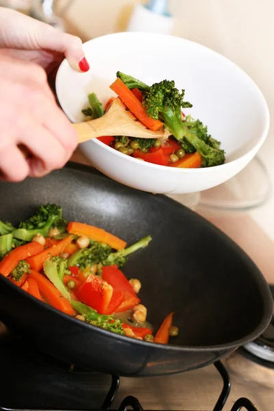 Cooking vegetables in wok pan