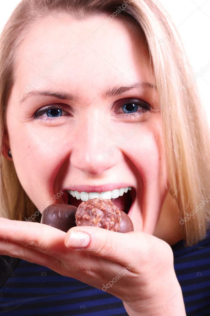 Smiling woman eating chocolate candies