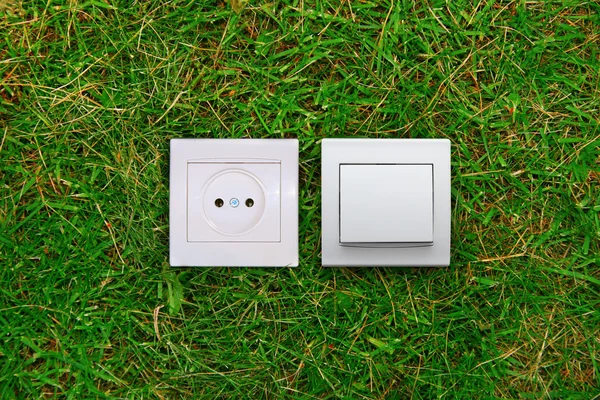 녹색 에너지의 개념: 전기 콘센트와 빛 잔디에 스위치 — 스톡 사진