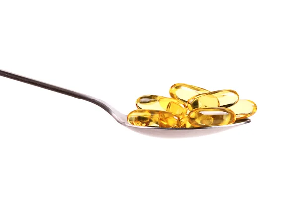 Spoon full of fish oil capsules — Stock Photo, Image