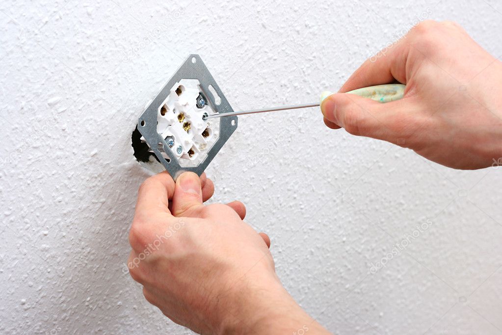 Electrician installing wall socket
