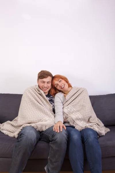Una joven pareja en un sofá — Foto de Stock