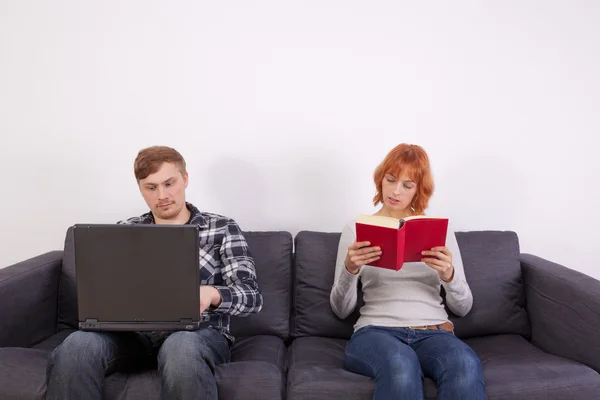 A young couple on a sofa — Stock Photo, Image