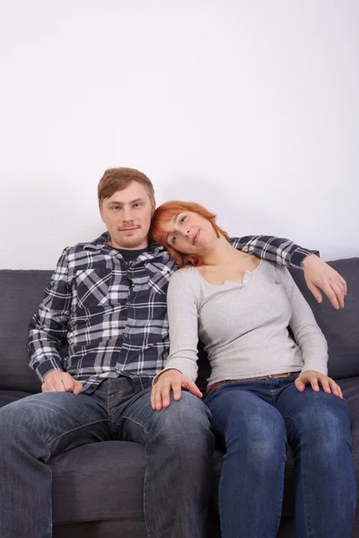 Um jovem casal em um sofá — Fotografia de Stock