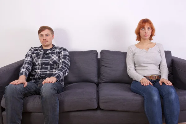 Una giovane coppia su un divano — Foto Stock
