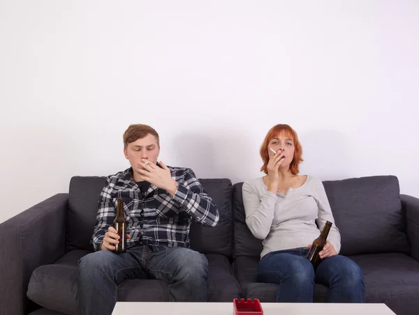 Um jovem casal em um sofá — Fotografia de Stock