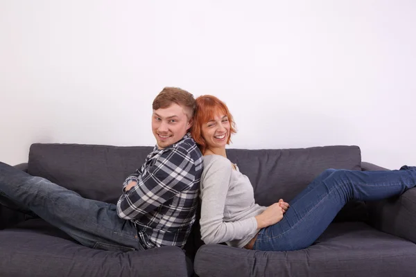 A young couple on a sofa — Stock Photo, Image