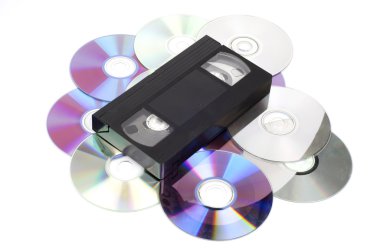 CD vs VHS. VHS cassette lay on the many CD disks isolated on whi clipart