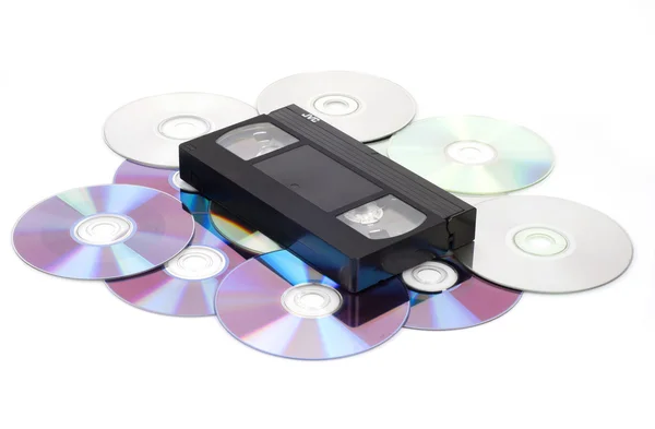 CD vs VHS. VHS cassette lay on the many CD disks — Stock Photo, Image