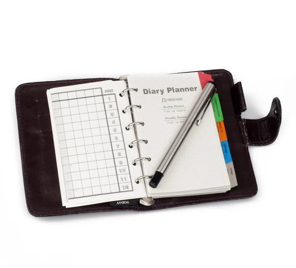 На странице "Дневника планировщика" открылся дневник с ручкой, которая лежала на i — стоковое фото