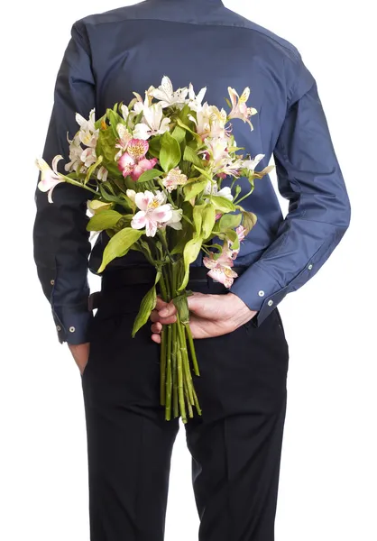 Człowiek posiada bukiet bukiet kwiatów, za jego plecami. na białym tle o — Zdjęcie stockowe