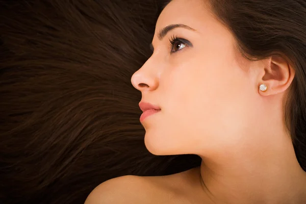 Schönes junges weibliches Gesicht mit langen Schönheitshaaren als Hintergrund — Stockfoto