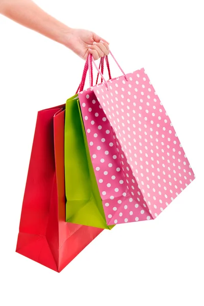 Mão feminina segurando sacos de compras coloridos — Fotografia de Stock