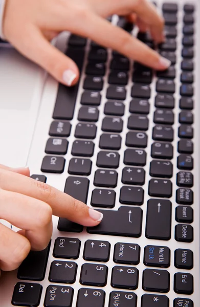 Gros plan de la main de la femme touchant les clés de l'ordinateur pendant le travail — Photo