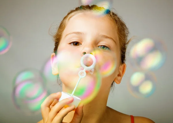Retrato de engraçado linda menina soprando bolhas de sabão — Fotografia de Stock
