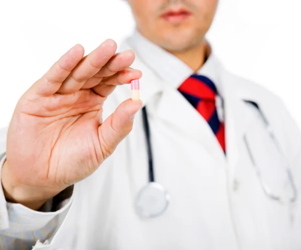 Fechar-se de um médico segurando uma pílula, isolado em branco — Fotografia de Stock
