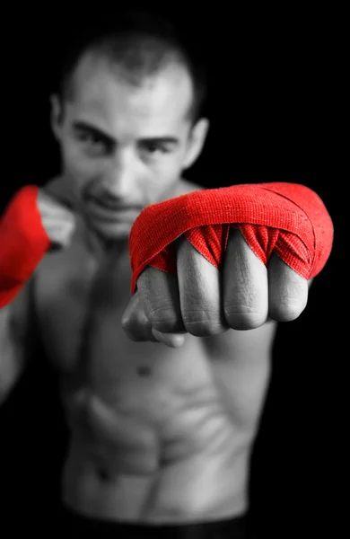 Joven boxeador peleando sobre fondo negro. Céntrate en la mano . — Foto de Stock