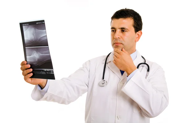 Junger Arzt schaut auf ein Röntgenbild, isoliert auf weißem Grund — Stockfoto